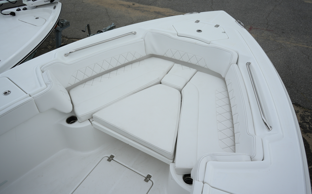 Front lounge of the Makaira 2600 with all cushions down, providing a large padded platform for relaxing.