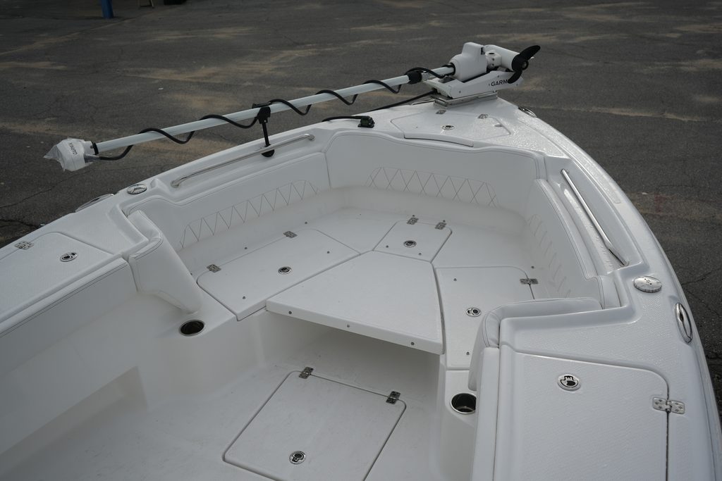 Front lounge of the Makaira 2800 with all cushions removed, revealing a large raised casting platform and several storage compartments.