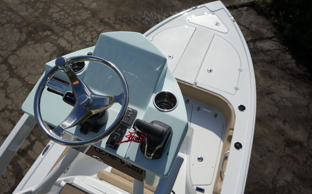 This image is shot from above the Blazer Bay 2440. In the foreground is the second station of the boat's half tower. In the background, there is the front deck and seating of the boat.